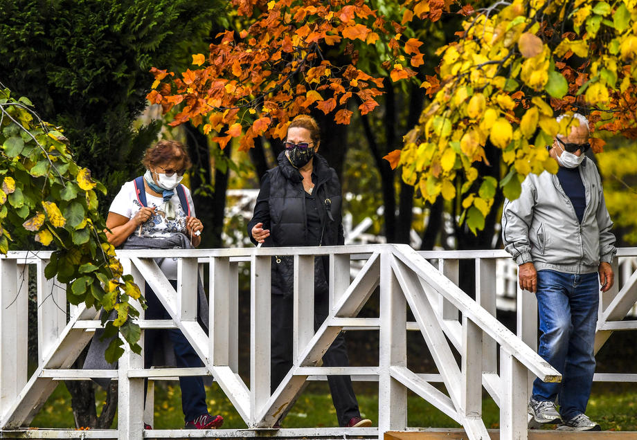 Njerëz me maska ​​mbrojtëse në parkun e qytetit në Shkup të vjeshtës Covid-19 koronavirus