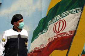 Маж проаѓа покрај мурал на кој се гледа националното знаме, на улица во Техран, Иран / Ноември 2020 / Фото: EPA-EFE/ABEDIN TAHERKENAREHEFE/ABEDIN TAHERKENAREH